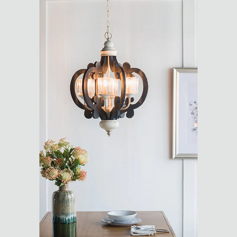 Blue wood and iron farmhouse pendant light with scrolled arms illuminated above dining table - Elirian