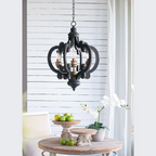 Black ornate pendant light with carved wood details hanging above wooden table - Elirian