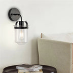 Modern black wall sconce with clear glass shade and chrome accents - Elirian