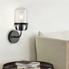 Modern black wall sconce with clear glass shade and curved arm - Elirian