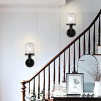 Modern black wall sconce with clear glass shade on staircase - Elirian